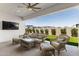 Relaxing covered patio with wicker furniture, a ceiling fan, and a view of the neatly landscaped backyard at 11899 N Spearfish St, Surprise, AZ 85388