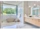 Luxurious bathroom with a freestanding tub, marble finishes, and a large window with scenic views at 6215 N Casa Blanca Dr, Paradise Valley, AZ 85253