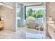 Spa-like bathroom with marble walls, modern fixtures, and a soaking tub with a view at 6215 N Casa Blanca Dr, Paradise Valley, AZ 85253