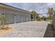 Spacious three-car garage with a stylish paved driveway and a glimpse of the tennis court at 6215 N Casa Blanca Dr, Paradise Valley, AZ 85253