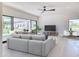 Bright living room with a modern gray sofa, large sliding glass doors to the patio, and a ceiling fan at 6215 N Casa Blanca Dr, Paradise Valley, AZ 85253