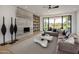 Stylish living room features a contemporary fireplace, built-in shelving, and large windows with backyard views at 6215 N Casa Blanca Dr, Paradise Valley, AZ 85253