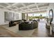 Bright living room with modern sofa and light hardwood floors offers stunning views of the pool at 6215 N Casa Blanca Dr, Paradise Valley, AZ 85253