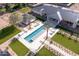 Aerial view of a luxurious pool area with lush landscaping and palm trees near the main house at 6215 N Casa Blanca Dr, Paradise Valley, AZ 85253