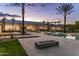 Inviting pool area featuring a modern fire pit, palm trees, and a beautifully lit exterior at twilight at 6215 N Casa Blanca Dr, Paradise Valley, AZ 85253