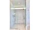 Elegant shower with marble walls, glass doors, and built-in shelving for toiletries at 6215 N Casa Blanca Dr, Paradise Valley, AZ 85253