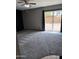 This bedroom features plush gray carpeting, a ceiling fan, and sliding glass doors leading to the backyard at 815 W Kiva Ave, Mesa, AZ 85210