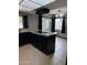 A kitchen with dark cabinets, granite countertops, tile flooring, and modern appliances at 815 W Kiva Ave, Mesa, AZ 85210