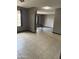 Open-concept living room with tile flooring, neutral paint, and a view into another room at 815 W Kiva Ave, Mesa, AZ 85210