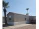 Tan mobile home with a carport and mature palm trees in front at 9431 E Coralbell Ave # 124, Mesa, AZ 85208