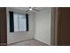 Small bedroom with window, blinds, and dark teal curtains at 12461 W Midway Ave, Glendale, AZ 85307