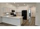 Modern kitchen with white cabinets, breakfast bar, and black appliances at 12461 W Midway Ave, Glendale, AZ 85307