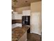 Stylish kitchen featuring white cabinets, stainless steel fridge, granite countertops, and tiled floors at 1480 E Harrison St, Gilbert, AZ 85295