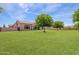 Large backyard with green grass and mature trees at 18654 W Solano Dr, Litchfield Park, AZ 85340