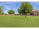 Spacious backyard with lush lawn and mature trees at 18654 W Solano Dr, Litchfield Park, AZ 85340