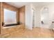 Bathroom with soaking tub, access to bedroom, and tile flooring at 18654 W Solano Dr, Litchfield Park, AZ 85340