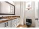 Small bathroom with marble countertop, white cabinets, and black toilet at 18654 W Solano Dr, Litchfield Park, AZ 85340