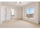 Bedroom with carpet flooring, large window, and ensuite bathroom at 18654 W Solano Dr, Litchfield Park, AZ 85340