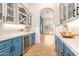 Butlers pantry with blue cabinets, granite counters, and wine storage at 18654 W Solano Dr, Litchfield Park, AZ 85340