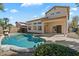 Outdoor living enhanced by a refreshing pool, patio, palms, and the beautiful house exterior beyond the verdant lawn at 19406 N 31St Way, Phoenix, AZ 85050