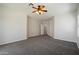 Spacious carpeted bedroom featuring a ceiling fan, and an arched entryway to the ensuite bath at 19406 N 31St Way, Phoenix, AZ 85050