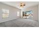 Bright bedroom with neutral carpet, a ceiling fan, and a sliding glass door to the backyard at 19406 N 31St Way, Phoenix, AZ 85050