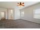 A bright, airy bedroom with neutral carpet, ceiling fan, two windows and access to the ensuite bathroom at 19406 N 31St Way, Phoenix, AZ 85050