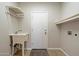 Functional laundry room equipped with a sink, rack, and ample storage space, plus washer/dryer hookups at 19406 N 31St Way, Phoenix, AZ 85050