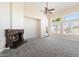 Cozy living room featuring a stone fireplace, neutral carpet, and large windows with natural light at 19406 N 31St Way, Phoenix, AZ 85050