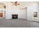 Open living space with a stone fireplace, neutral carpet, and a ceiling fan for comfort at 19406 N 31St Way, Phoenix, AZ 85050