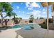 A stunning backyard pool area complete with a serene rock waterfall feature, palm trees, and lush greenery at 19406 N 31St Way, Phoenix, AZ 85050
