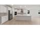 Bright kitchen with stainless steel appliances, white cabinetry, and a large center island at 7674 W Cactus Wren Way, Florence, AZ 85132