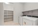 Functional laundry room with shelving and modern washer and dryer at 7674 W Cactus Wren Way, Florence, AZ 85132