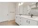 Luxurious bathroom features double sink vanity, white cabinets and countertops, and a large mirror for a spacious feel at 7682 W Mockingbird Way, Florence, AZ 85132