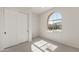 Bedroom featuring an arched window, sliding closet door, and carpet at 7682 W Mockingbird Way, Florence, AZ 85132