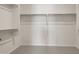 Walk-in closet with minimalist design, open shelving for optimal storage, and neutral-toned carpet for a clean look at 7682 W Mockingbird Way, Florence, AZ 85132