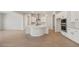 Bright kitchen featuring a center island with a sink, white cabinets, and stainless steel appliances at 7682 W Mockingbird Way, Florence, AZ 85132