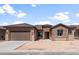 Charming single-story home with a stone facade, tile roof, and a spacious two-car garage at 7736 W Mockingbird Way, Florence, AZ 85132