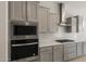 Modern kitchen with built-in oven, sleek range hood, and stylish gray cabinetry at 7736 W Mockingbird Way, Florence, AZ 85132