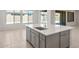 Close-up of a gray kitchen island with modern countertops and a sink, with sliding glass doors in background at 7736 W Mockingbird Way, Florence, AZ 85132