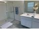 Bright bathroom featuring dual sinks, a glass shower, and modern decor at 26722 N 174Th Ln, Surprise, AZ 85387
