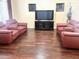 Spacious living room featuring hardwood floors and two red leather reclining sofas at 5431 E Shea Blvd, Scottsdale, AZ 85254