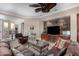 Comfortable living room with stone accent wall, ceiling fan, and large leather couch at 28831 N 128Th Dr, Peoria, AZ 85383