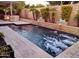 Beautiful backyard pool with spa, stone accents, mature landscaping, and ample deck space for entertaining at 28831 N 128Th Dr, Peoria, AZ 85383