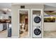 Bathroom and laundry area features tiled floors, stacked washer/dryer, and desert scene decor at 4600 N 68Th St # 313, Scottsdale, AZ 85251