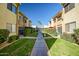 Charming condo exterior with lush landscaping, palm trees, and inviting walkway to the parking area at 4600 N 68Th St # 313, Scottsdale, AZ 85251
