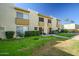 Well-maintained condo exterior with lush green lawn, mature hedges, and a walkway at 4600 N 68Th St # 313, Scottsdale, AZ 85251