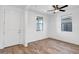 Bright bedroom featuring wood-look tile flooring, white walls, and a ceiling fan at 5534 W Banff Ln, Glendale, AZ 85306