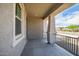 View of a covered front porch with grey brick accents, black railing, and view of street at 5534 W Banff Ln, Glendale, AZ 85306
