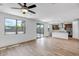 Spacious living room with wood-style floors, large windows, and an open layout to the kitchen at 5534 W Banff Ln, Glendale, AZ 85306